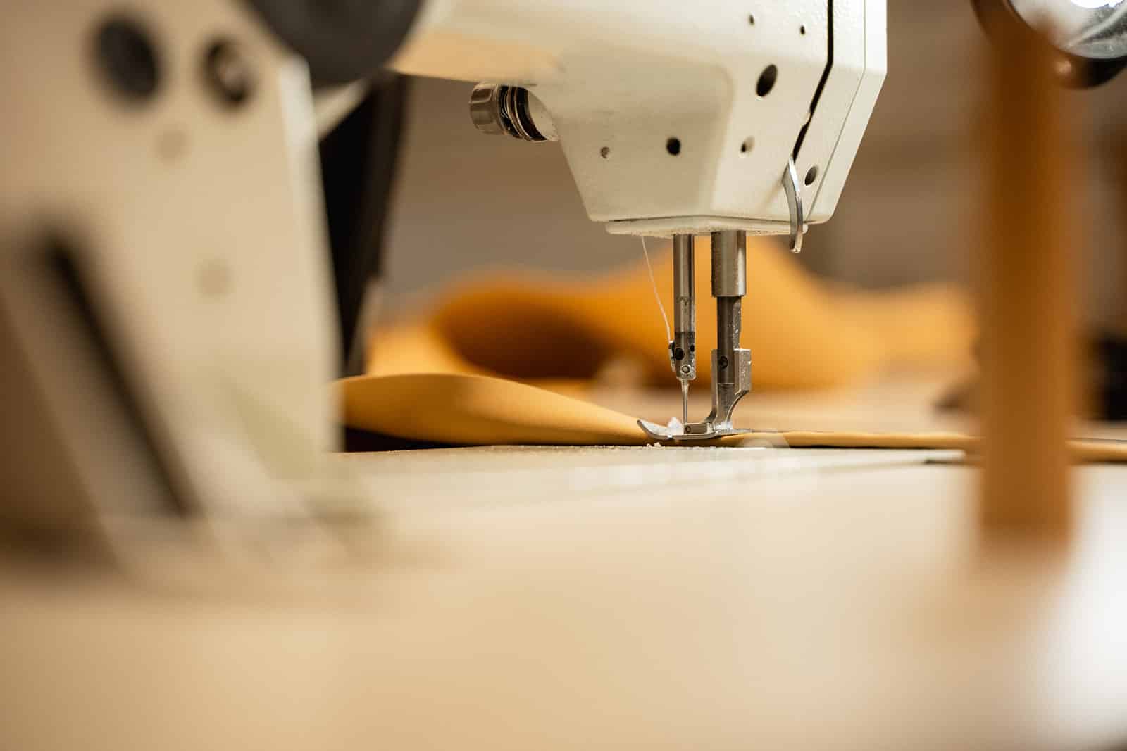 Detail van de speciale naaimachine die de lussenbanden afwerkt en aan de tenten naait