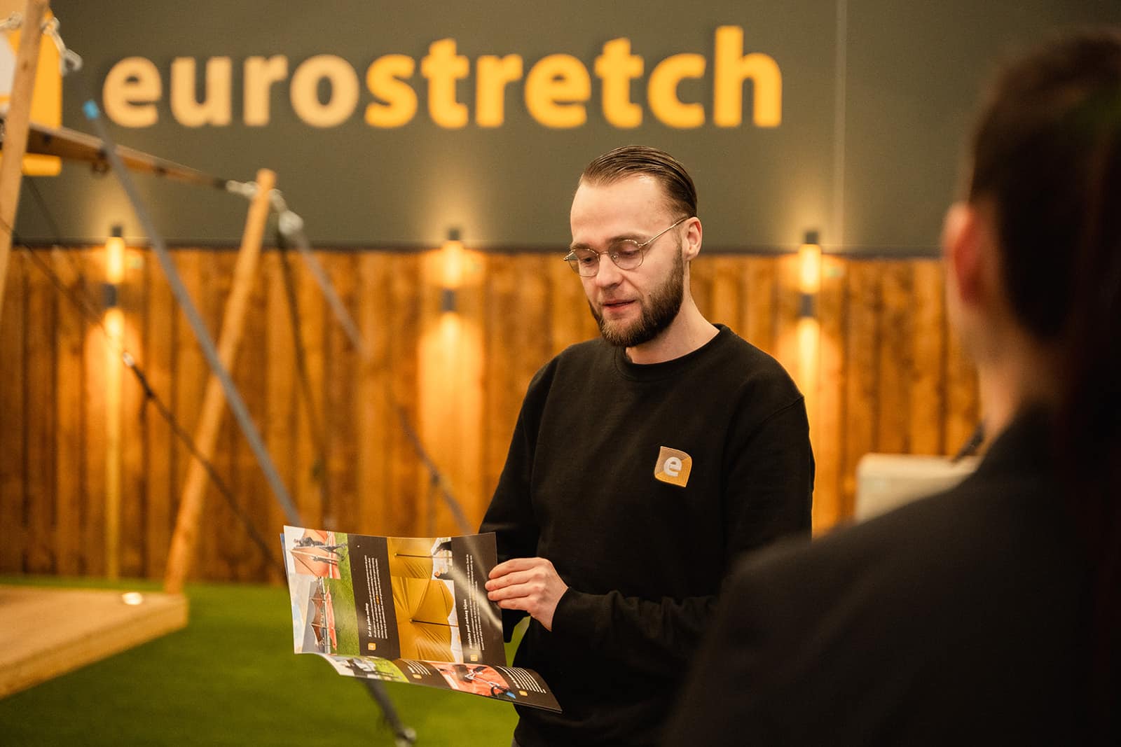 Jurrian laat handleiding zien aan klant in de stretchtenten showroom